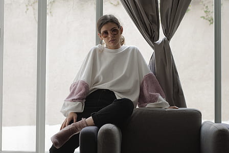 woman sitting on sofa chair near wall thumbnail