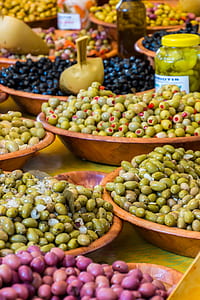 bowls of green olives on yellow table thumbnail
