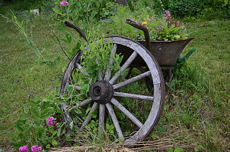 carriage wheel leaning on wheelbarrow thumbnail