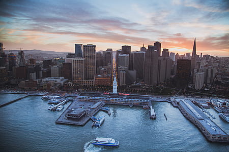 aerial photography of highrise building beside dock under gloomy sky thumbnail