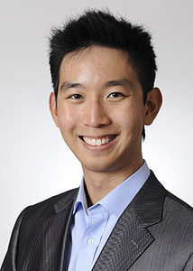 smiling man in black and gray pinstriped suit jacket thumbnail