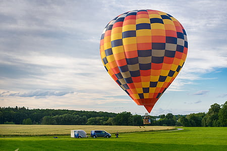 yellow and multicolored hot air balloon on mid air at daytime thumbnail