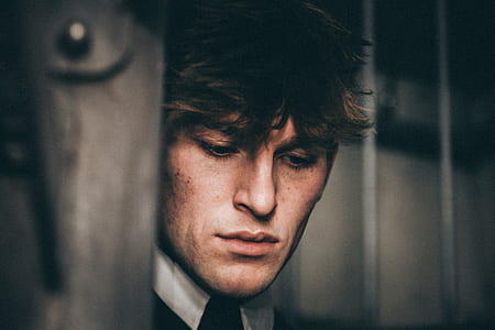 man wearing black and white collared top closeup photography thumbnail