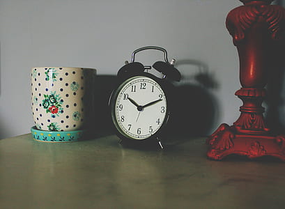 black alarm clock on brown wooden table thumbnail