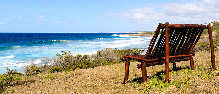 brown wooden bench near seashore thumbnail