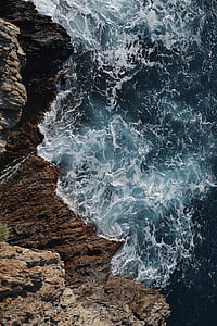 aerial photo of body of water beside mountain thumbnail