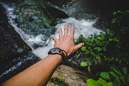 person showing arm wearing watch over water stream thumbnail