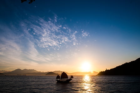 silhouette photo of canoe near islands thumbnail
