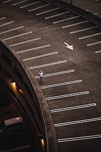 man in white top walking beside gray road at daytime thumbnail
