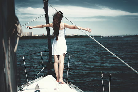 woman standing on boat edge while open arms thumbnail