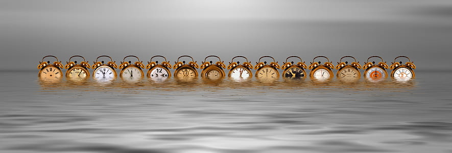assorted-color twin bell alarm clocks floating in body of water thumbnail