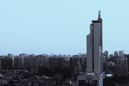 grayscale photo of high-rise building near city buildings thumbnail