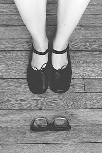 grayscale photography of person next to eyeglasses on floor thumbnail
