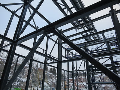 metal building frame beside snow covered hills thumbnail