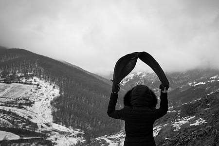 person facing the snow capped mountains thumbnail