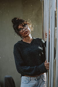 man in grey knit V-neck sweater holding on stand thumbnail