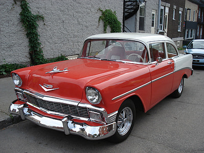 red and white vehicle parked beside concrete pathway at daytime thumbnail