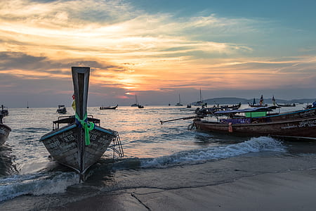boats docking on seashore at golden hour thumbnail