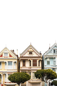 three beige and blue concrete houses near with green trees in front thumbnail