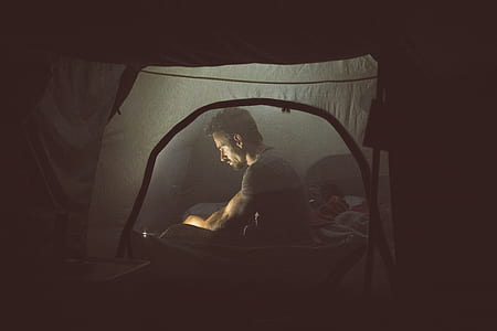 man sitting in tent at nighttime thumbnail