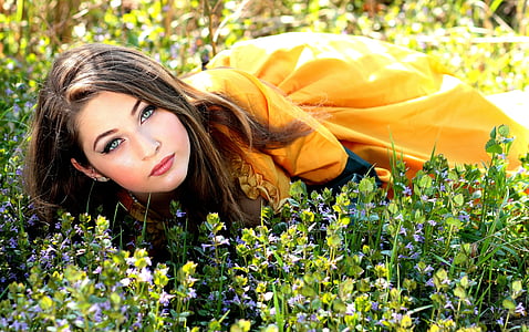 woman wearing yellow dress laying on green plants thumbnail