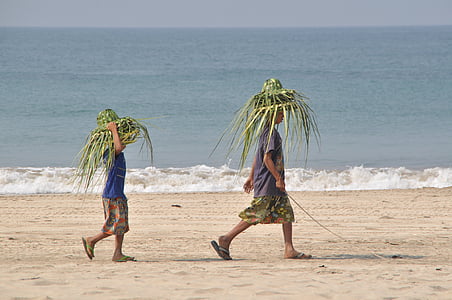 two boys walking on sand near seashore during daytime thumbnail