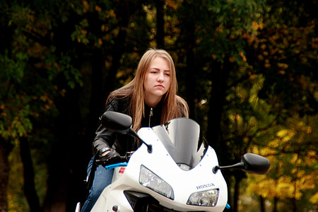 woman riding white Honda sports bike thumbnail