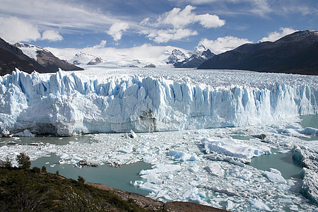 ice berg near mountain under blue sky thumbnail