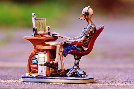 skeleton sitting in front of desk ceramic figurine thumbnail
