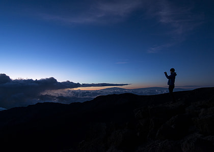 silhouette of person standing on top of mountain thumbnail