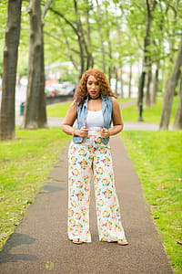 Woman in White Shirt with Denim Vest and Floral Pants thumbnail