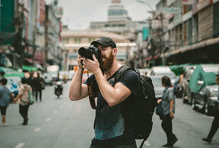 selective focus photo of man wearing black t-shirt about to take picture thumbnail