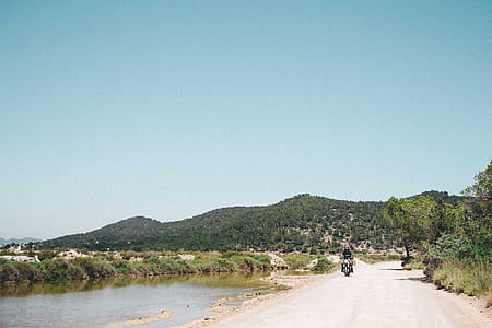 A young motorcyclist on a hilly road in sunshine thumbnail