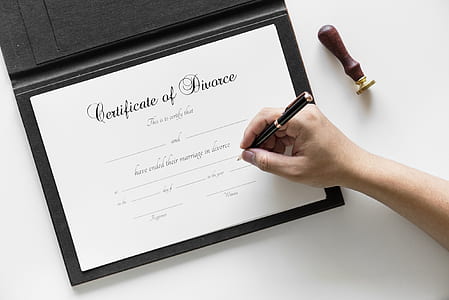 person writing on certificate inside well lighted room thumbnail