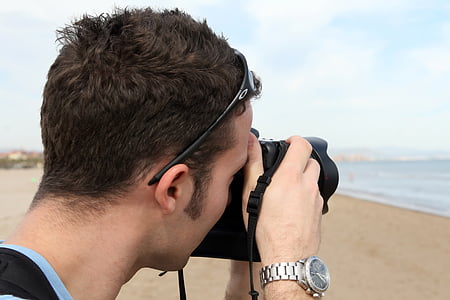 man taking a photo at the beach using DSLR camera thumbnail