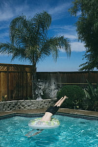 man diving into swimming pool during daytime thumbnail
