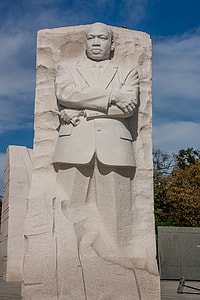 standing man statue under cloudy sky thumbnail