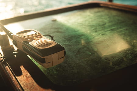 Close-up Photo of White and Black Two-way Radio on Green Glass Surface thumbnail