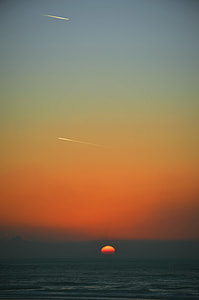 sun setting over the horizon under clear sky thumbnail