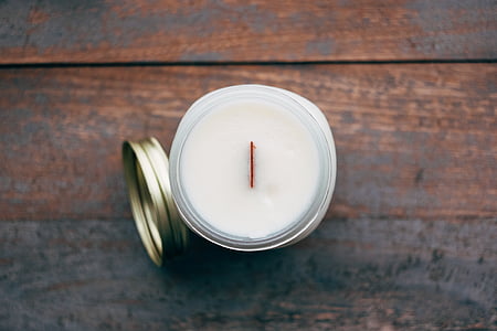 opened white votive candle on brown surface thumbnail