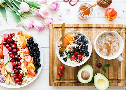 sliced avocado beside white ceramic bowl and cup on brown wooden chopping board thumbnail
