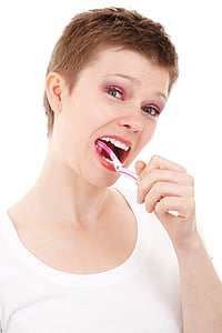 woman using white and pink toothbrush thumbnail