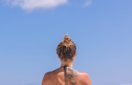 woman with back tattoo during day time thumbnail