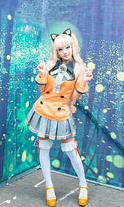 women's orange and gray costume standing near teal and blue textile thumbnail