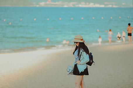 Girl in Cyan Jacket Walking on Beach thumbnail