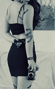 grayscale photo of woman holding SLR camera thumbnail