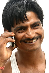 man smiling while holding white candybar phone thumbnail