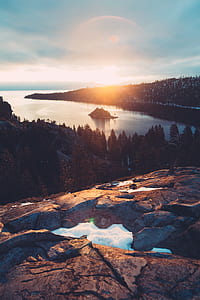 island between body of water under sun rays thumbnail