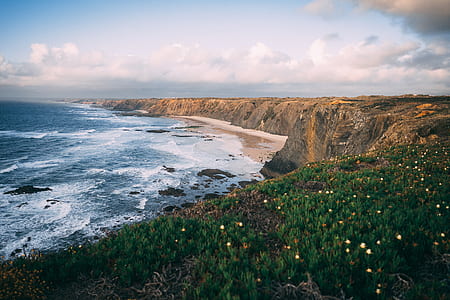 aerial photography of mountain cliff by the sea thumbnail