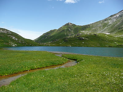 blue calm body of water near mountain at daytime thumbnail